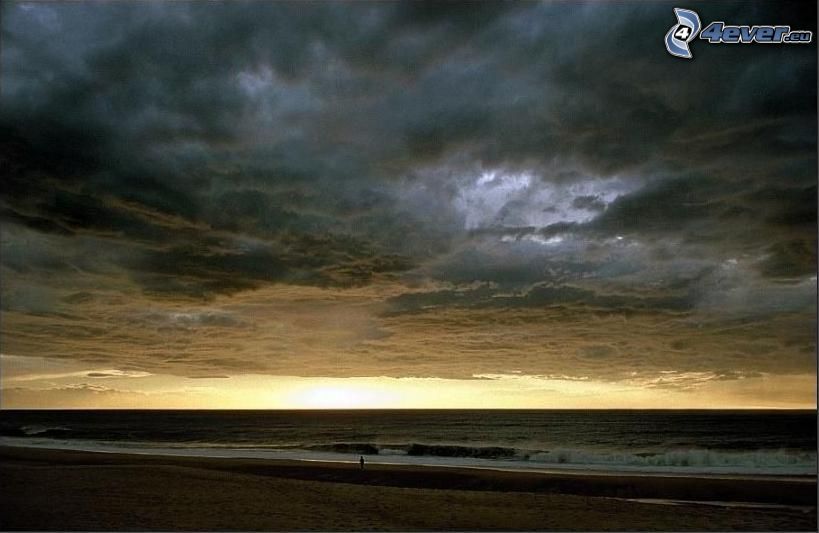 Dunkle Wolken über dem Strand, Dunkler Sonnenuntergang, stürmisches Meer