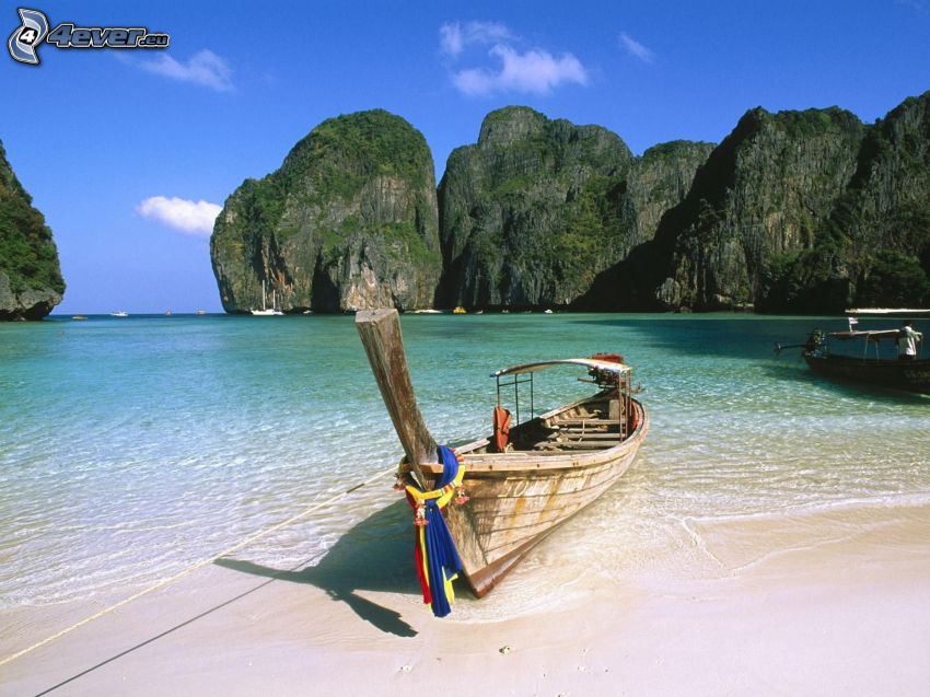 Boot in der Bucht auf Phi Phi Islands, Holzboot, Thailand, azurblaues Sommermeer, Felsen