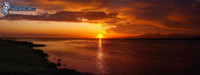 Orange Sonnenuntergang über dem Meer, Küste