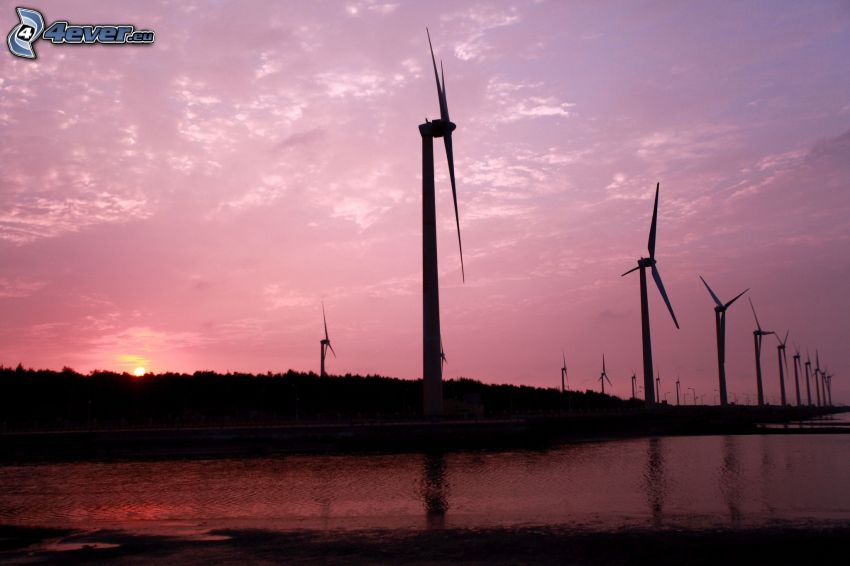 Windkraftanlagen beim Sonnenuntergang, lila Himmel