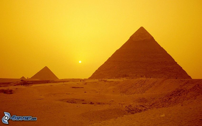 Egyptiska pyramiderna vid solnedgång, orange himmel, svag sol