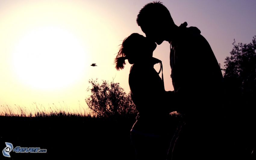 silhuett av ett par, kyss, solnedgång