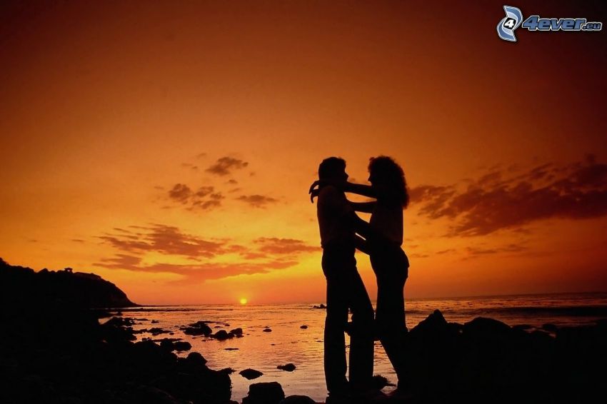 silhuett av ett par, solnedgång över havet, kärlek, kvällsjus