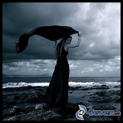kvinna på strand, svart klänning
