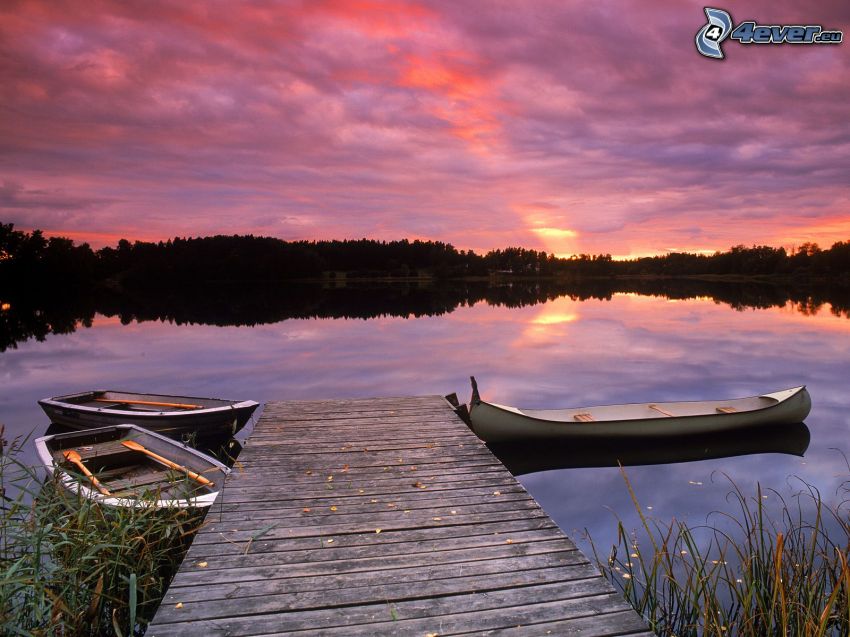 båtar på sjö, träbrygga, lila solnedgång