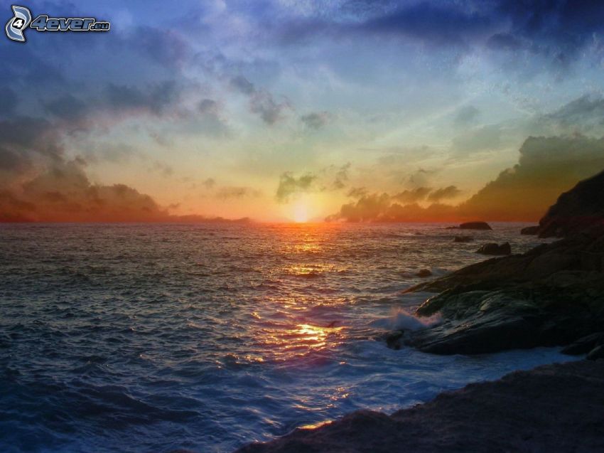 solnedgång över hav, stenig kust, himmel
