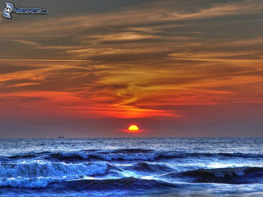 solnedgång över hav, vågor vid kusten