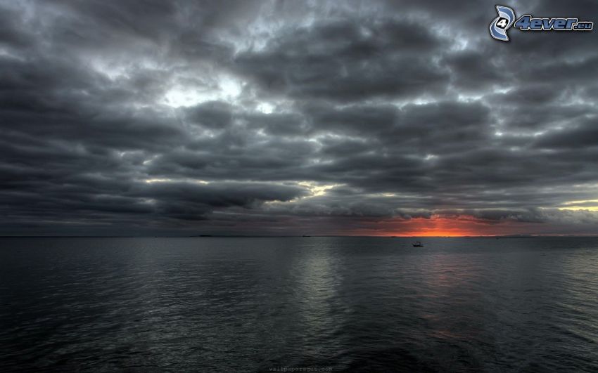 solnedgång över havet, mörka moln, mörkt hav