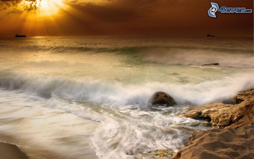solnedgång över havet, stormigt hav, vågor vid kusten