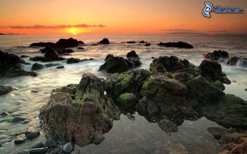 solnedgång över havet, stenar