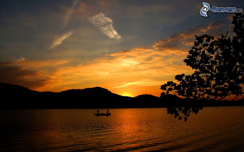 solnedgång över sjö, fiskare