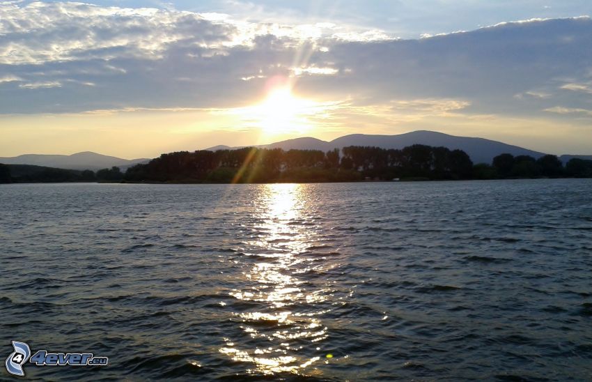 solnedgång över sjö, himmel, bergskedja, reflektion av solen
