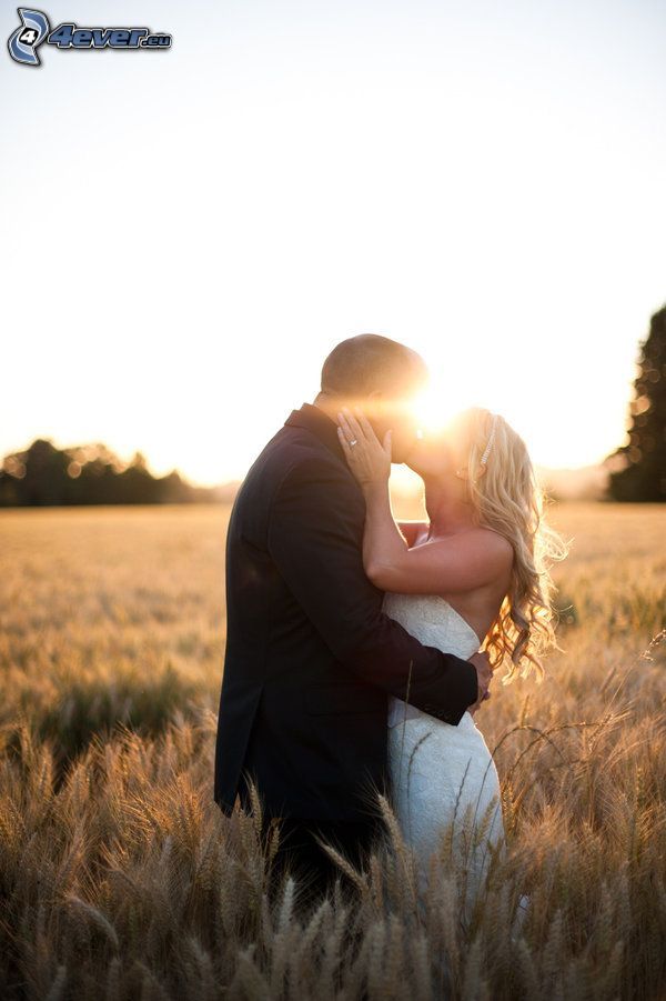 Beso en la puesta del sol, recién casados