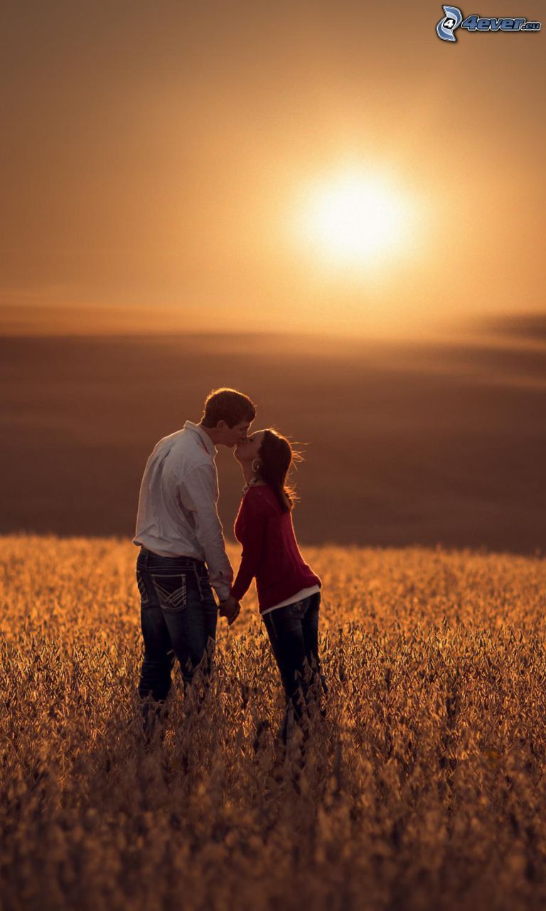 beso en un campo, puesta del sol