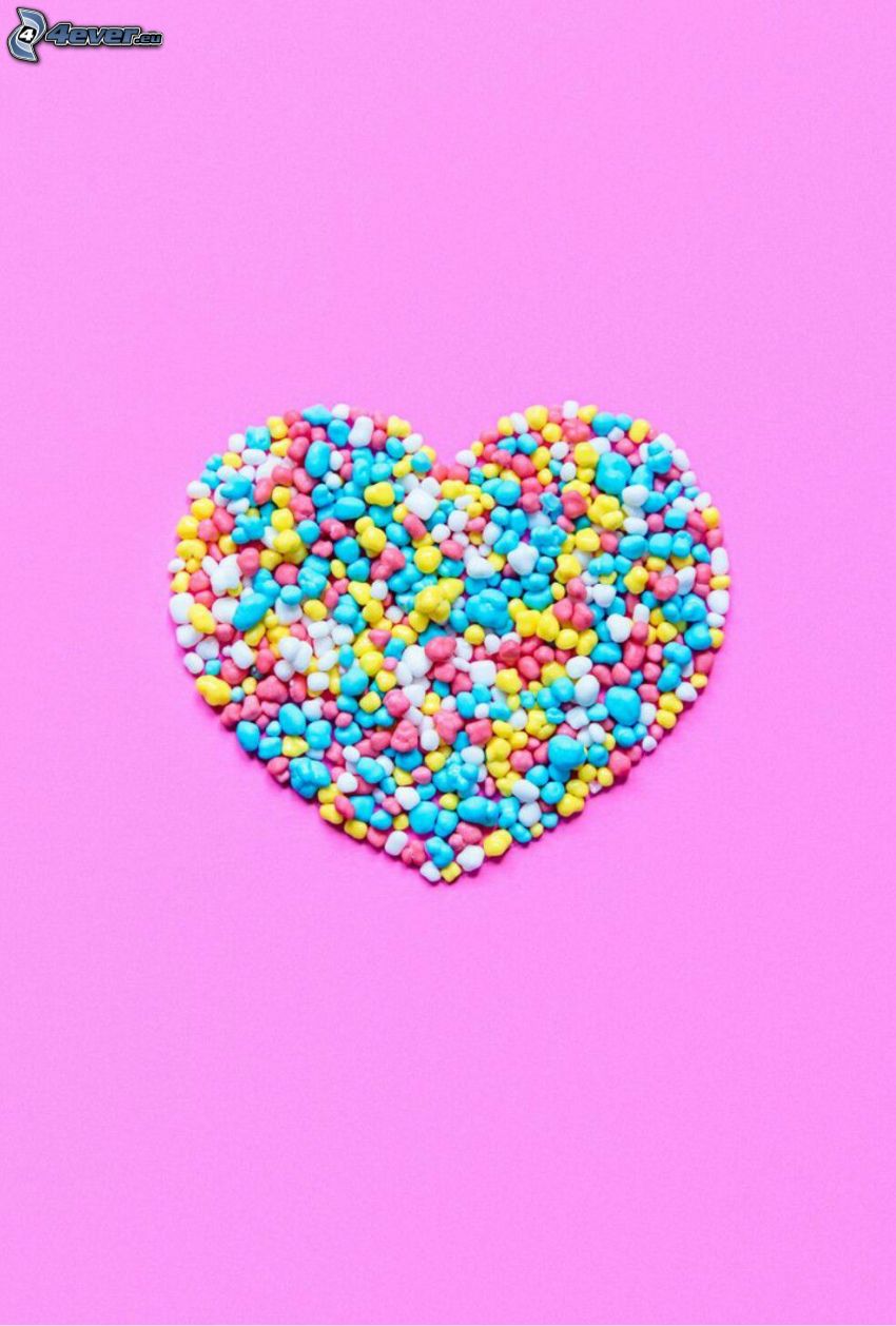 caramelos, corazón, fondo de color rosa