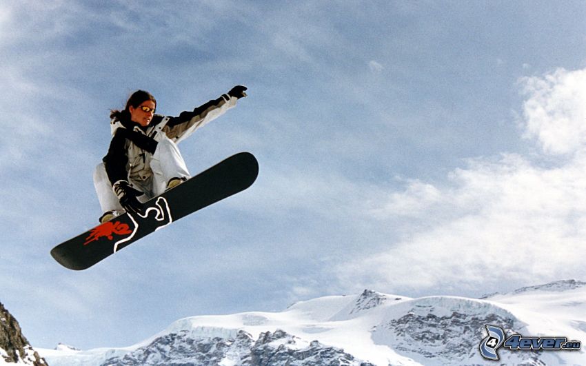 salto en tabla de snowboard, colinas cubiertas de nieve