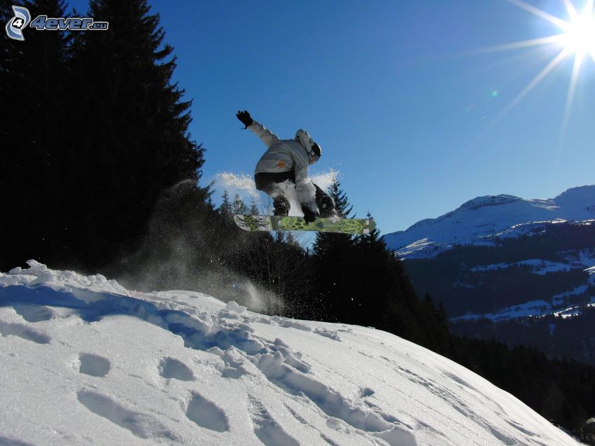 salto en tabla de snowboard, montañas