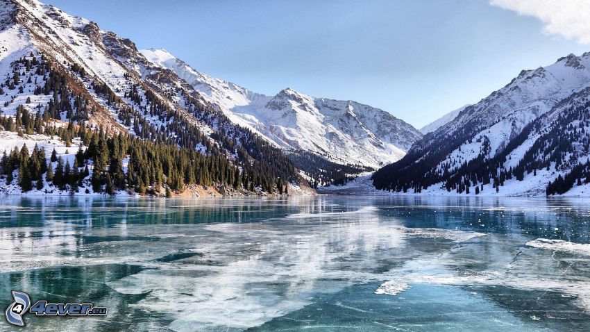 lago congelado, colinas cubiertas de nieve