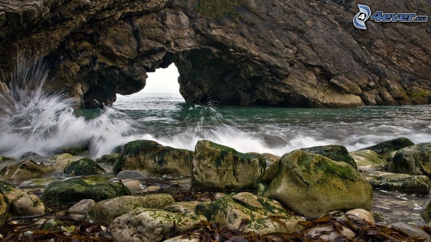 puerta rocosa en el mar, olas en la costa