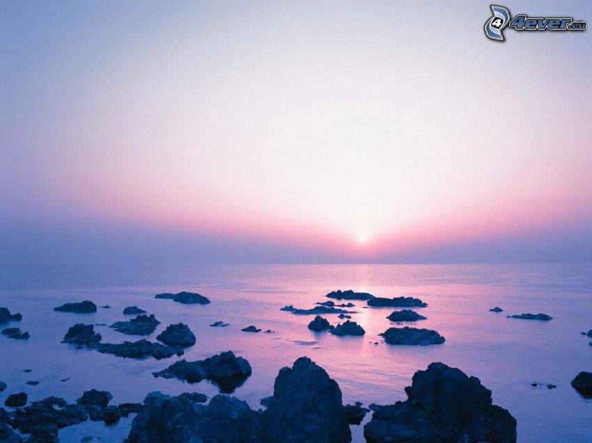 puesta de sol sobre el mar, cielo púrpura, océano, rocas, costa