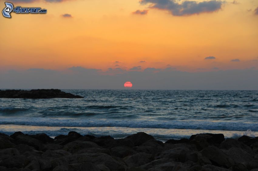 puesta de sol sobre el mar, costa rocosa