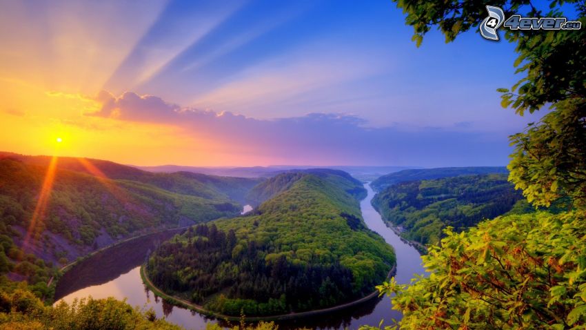 puesta de sol detrás de las montañas, río, bosque