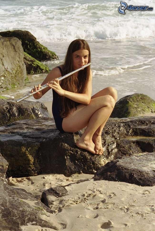 chica en la playa, tocar la flauta