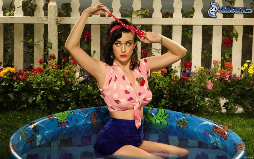 Katy Perry, mujer en piscina, cerco de madera, flores