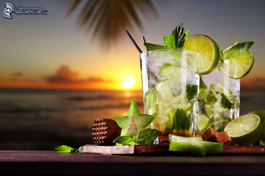 mojito, boissons mélangées, limes, feuilles de menthe, couchage de soleil à la mer