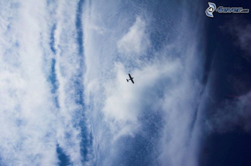 avion dans le ciel, nuages