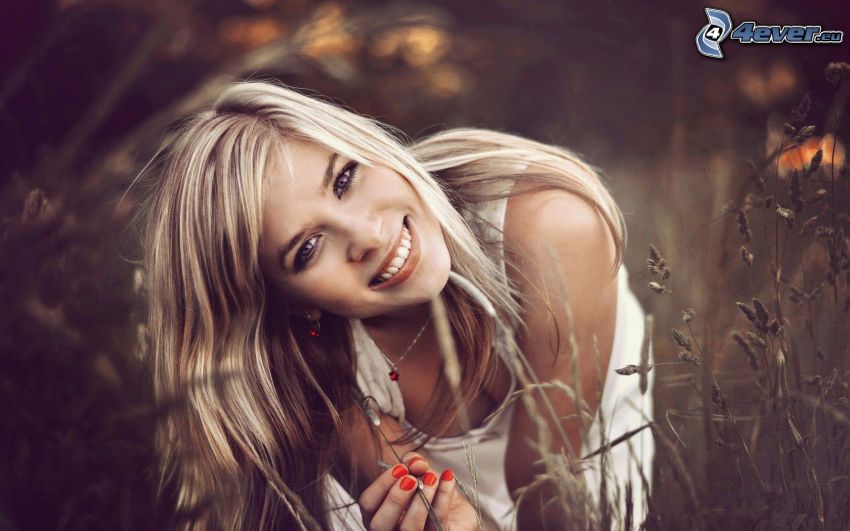 fille dans l'herbe, blonde, sourire