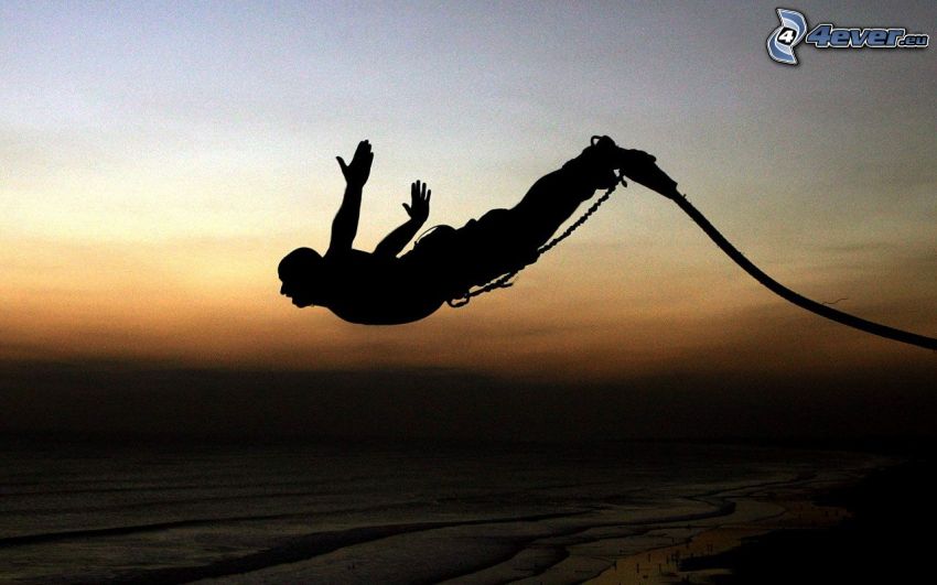 Saut à l'élastique, silhouette d'un homme, mer, côte, après le coucher du soleil