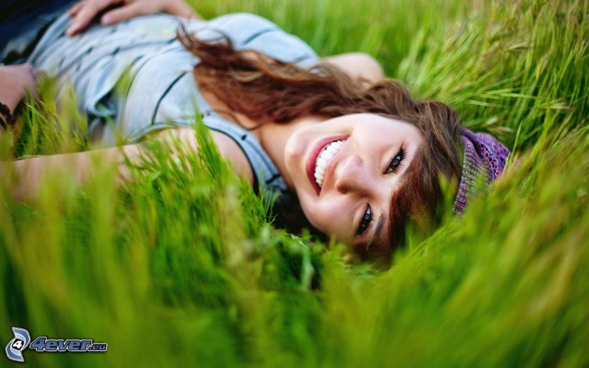 fille dans l'herbe, sourire