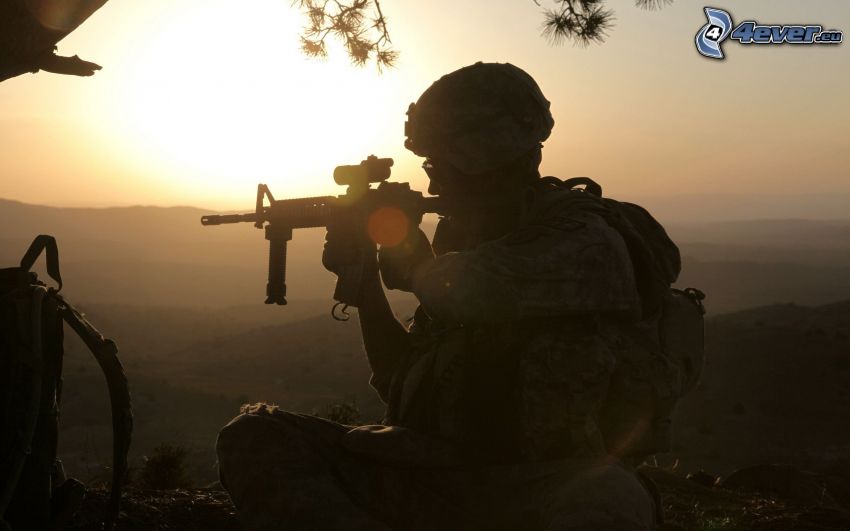 le soldat avec l'arme, silhouette d'un homme, coucher du soleil