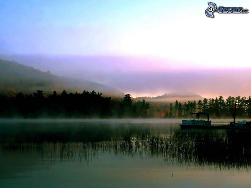 le bateau sur le lac, brume au-dessus de la forêt