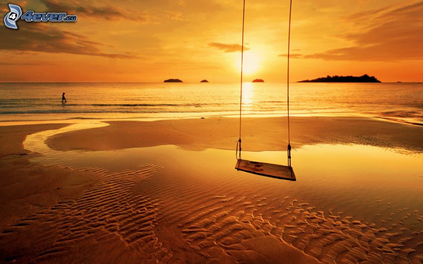 balançoire, couchage de soleil sur la mer, plage de sable, ciel orange