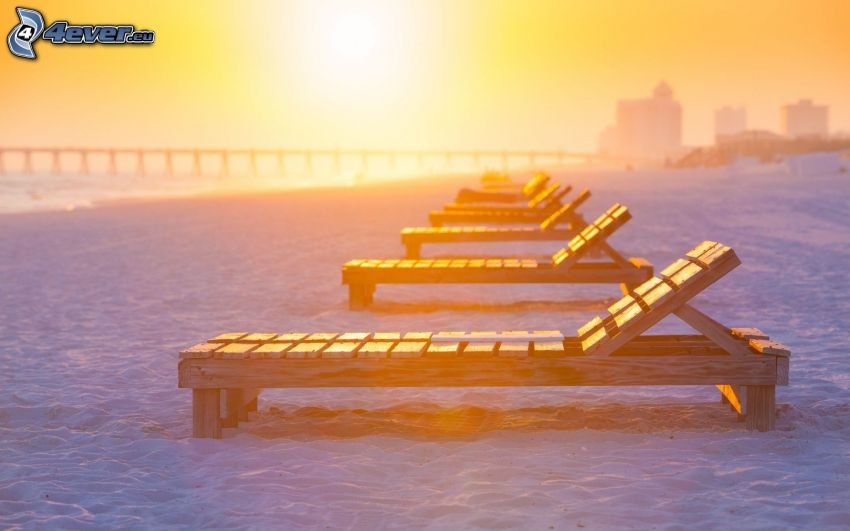 chaises longues sur la plage, coucher du soleil