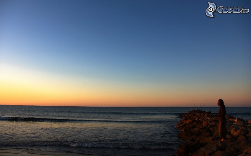 mer, après le coucher du soleil, silhouette de femme