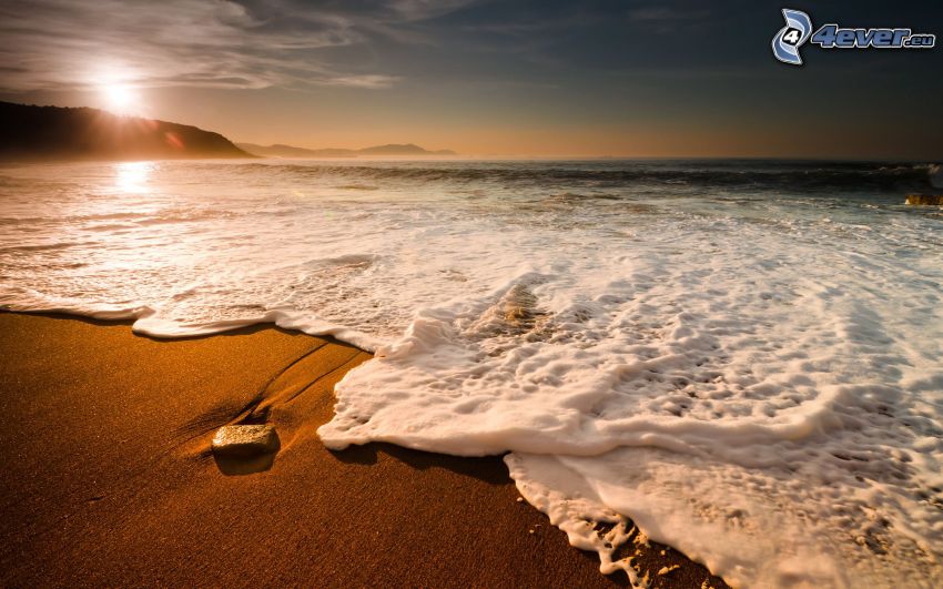 plage au couchage du soleil, vagues sur le rivage, mer