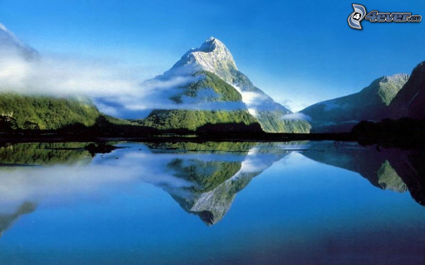 montagne enneigée au-dessus du lac, nuages, surface de l´eau calme