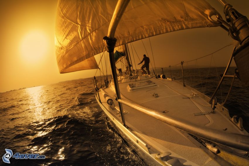 bateau à voile, coucher du soleil orange sur la mer