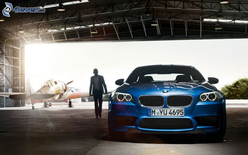 BMW M5, homme en costume, toit, avion