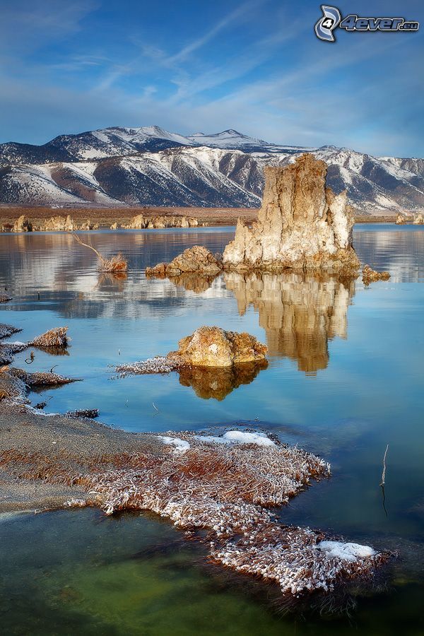roccia, lago, colline coperte di neve