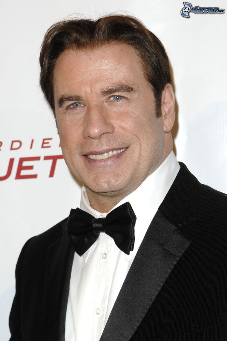 John Travolta, férfi öltönyben, csokornyakkendő, mosoly