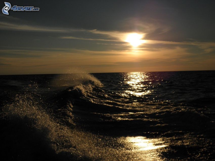 naplemente a tenger fölött, hullámok