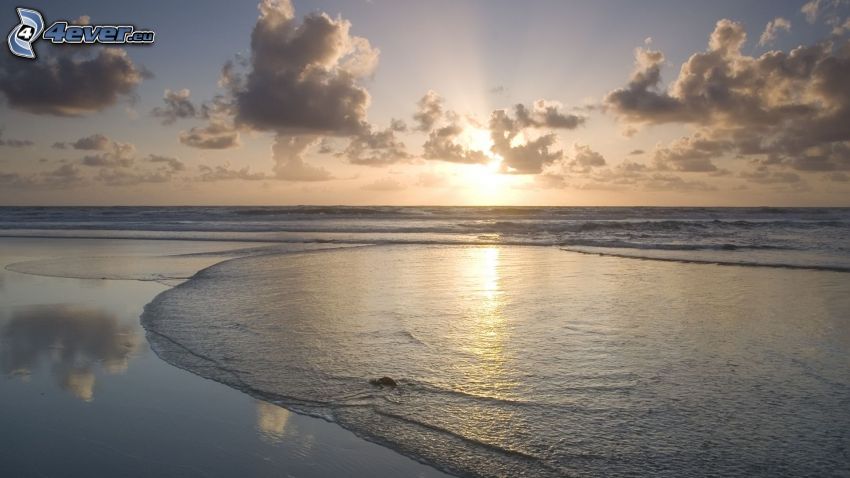 naplemente a tenger fölött, strand, felhők