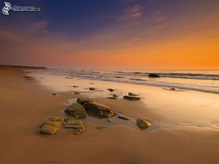 strand napnyugta után, homokos tengerpart, kövek