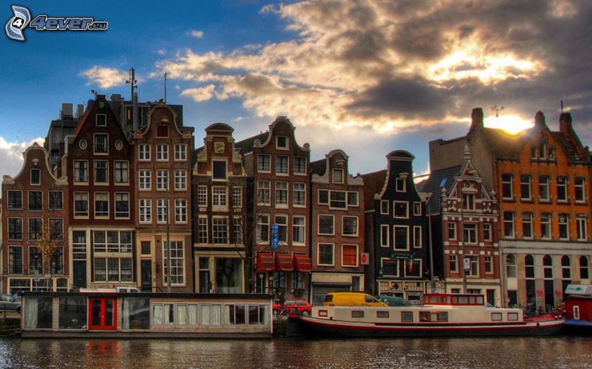 Amsterdam, kanał, statki, domy, zachód słońca w mieście, ciemne chmury
