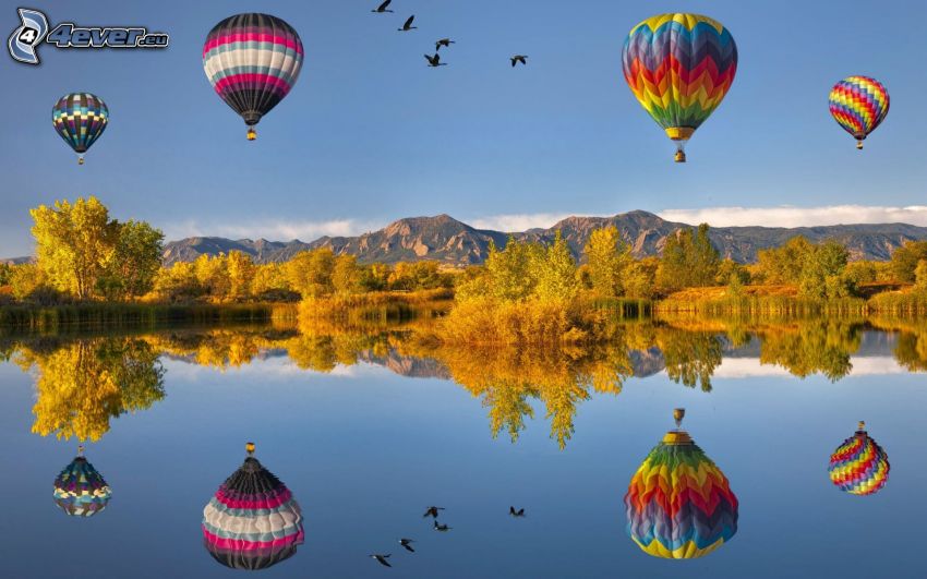 latające balony, jezioro, odbicie, żółte drzewa, niebo, ptaki, skaliste wzgórza