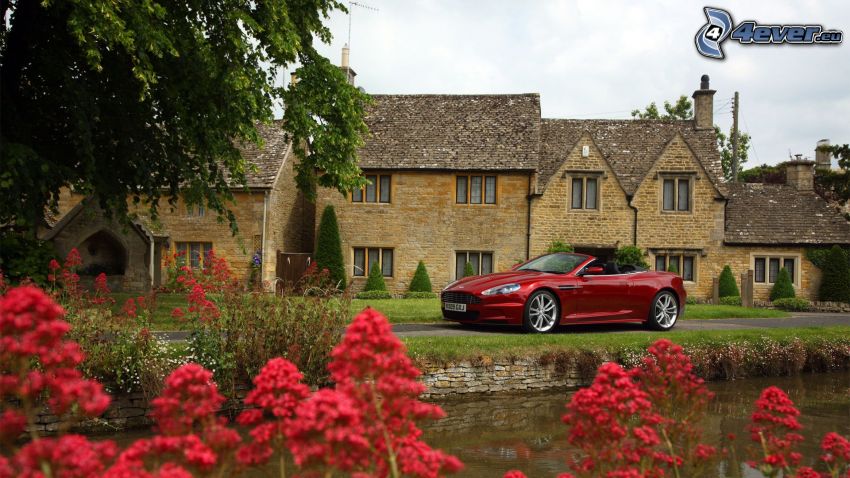 Aston Martin DBS, domy z kamienia, strumyk, czerwone kwiaty, angielska wieś